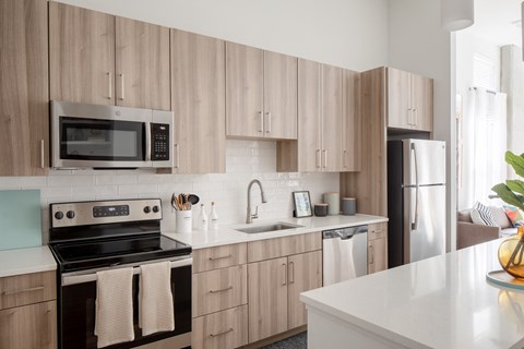 A kitchen with wooden cabinets and a black stove top oven.