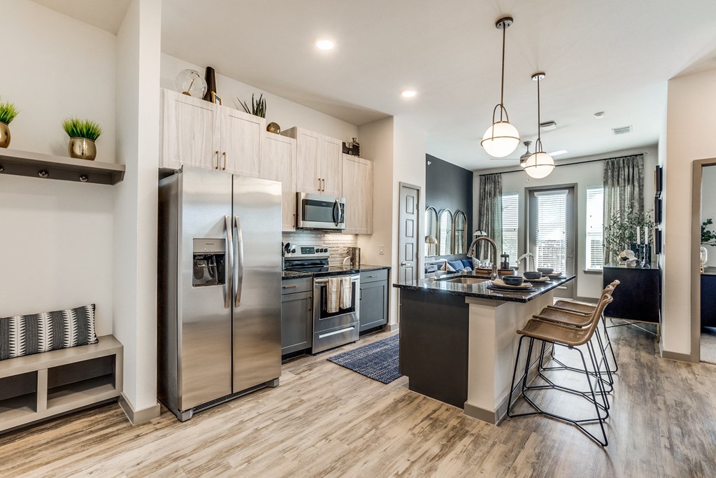 an open kitchen with stainless steel appliances and a large island