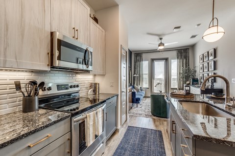 an open kitchen with stainless steel appliances and granite counter tops