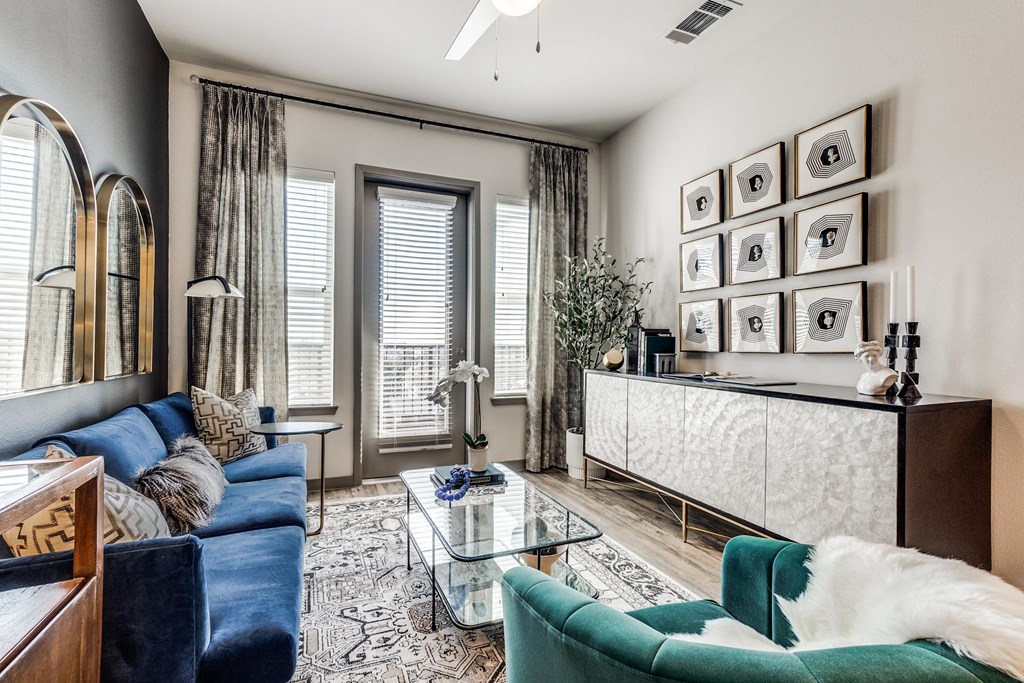 a living room with a blue couch and a glass coffee table