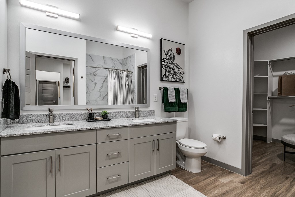 a bathroom with a large mirror and a toilet and a sink
