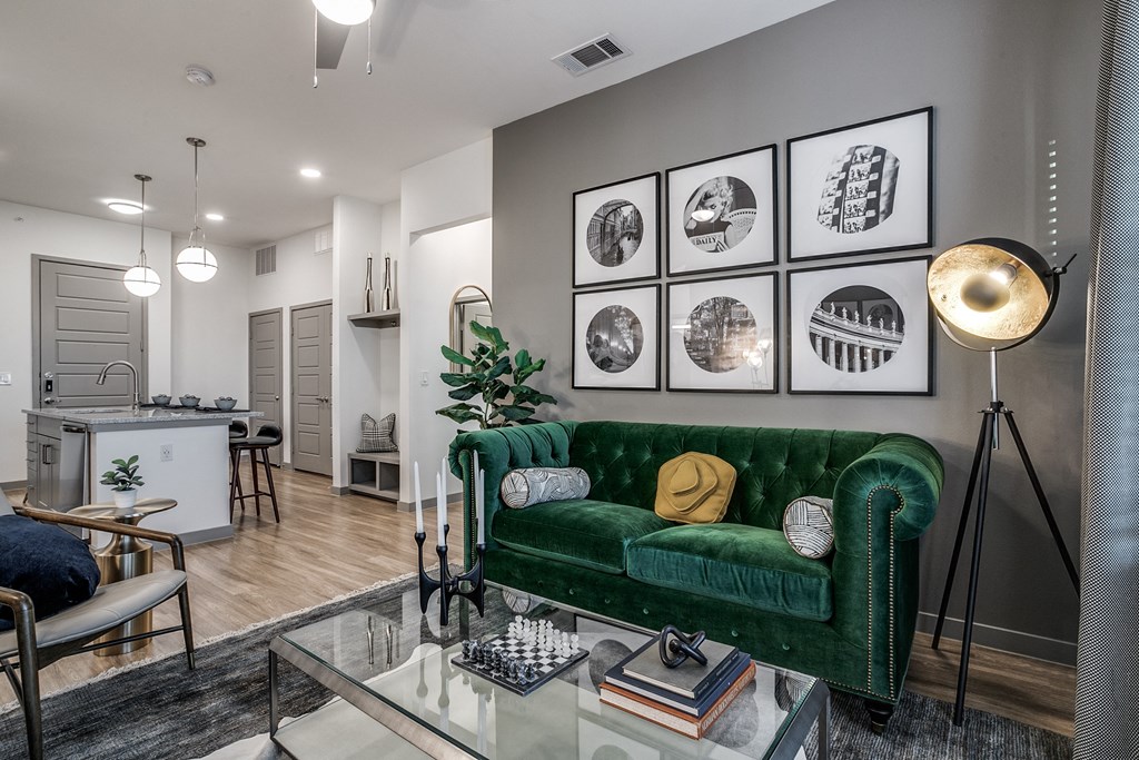 a living room with a green couch and a glass table