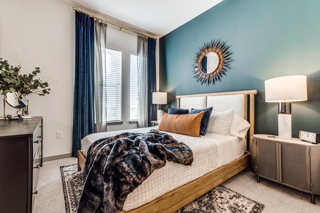 a bedroom with blue walls and a bed with a blanket