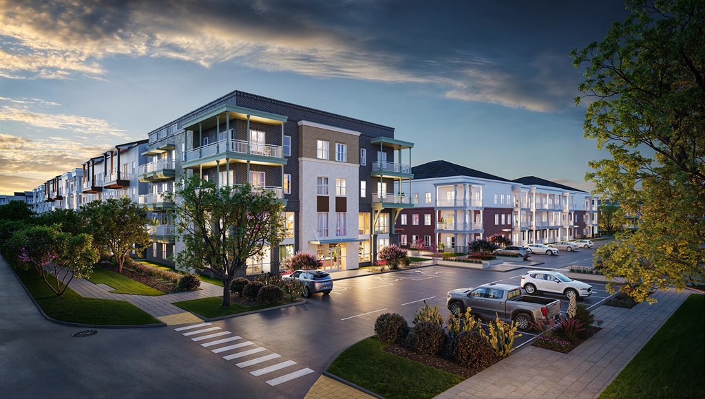 A modern apartment complex with cars parked in the driveway.
