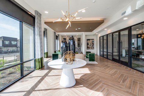 A modern dining room with a white table and a chandelier.
