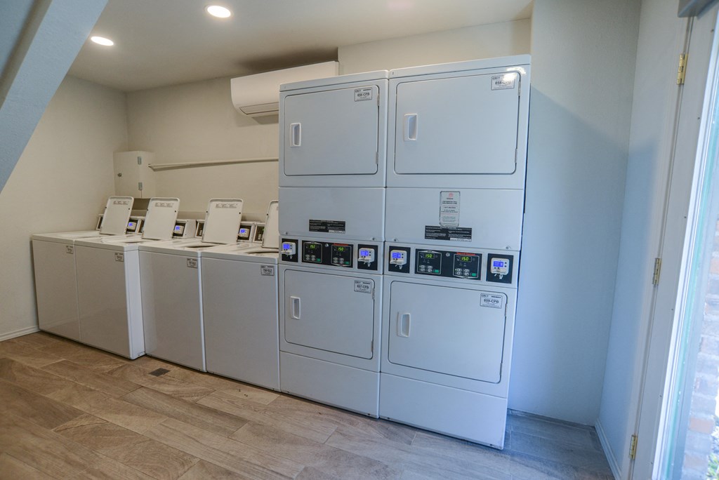 a row of white washers and dryers in a room