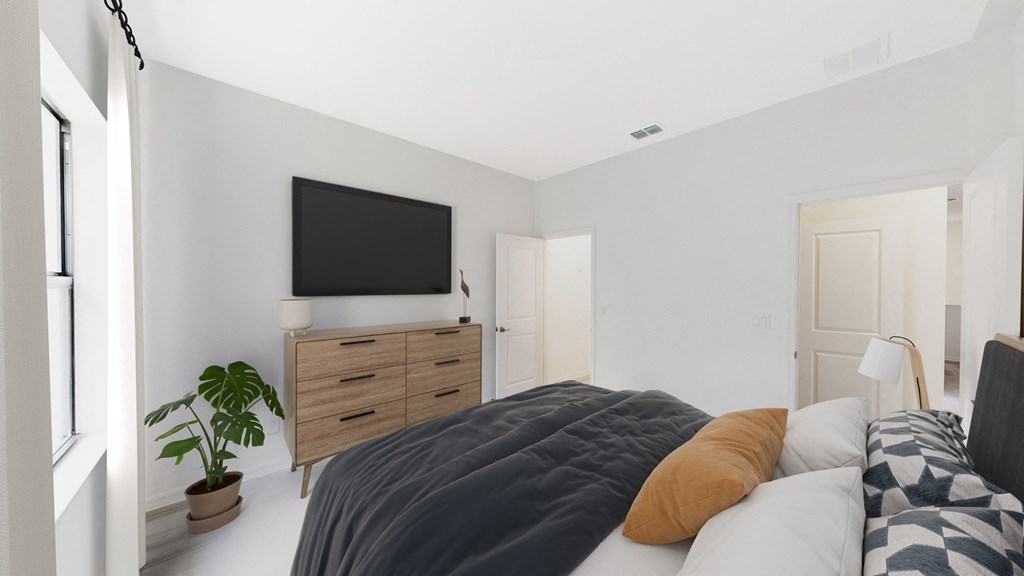 a bedroom with a bed and a tv on the wall