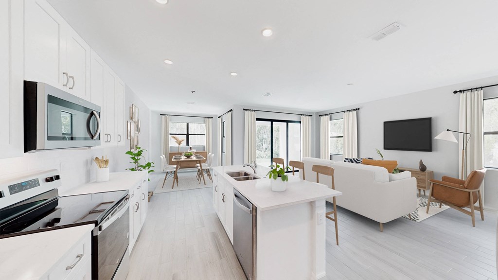a white living room with a kitchen and a tv