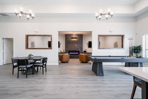 a game room with a ping pong table and chairs