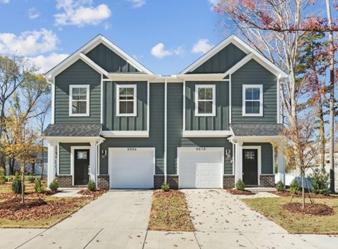 A two-story house with a garage on the first floor and a front porch on the second.