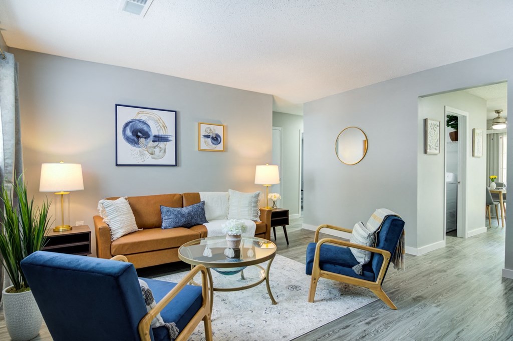 Model living room with blue chairs and a brown couch