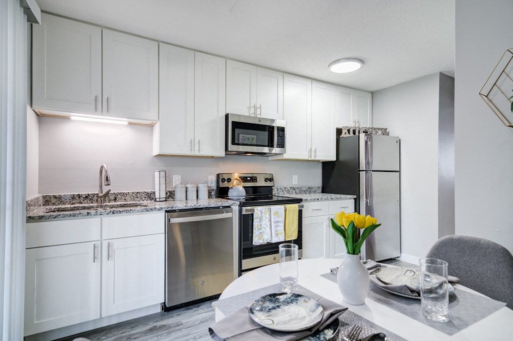 a renovated kitchen with white cabinets and stainless steel appliances