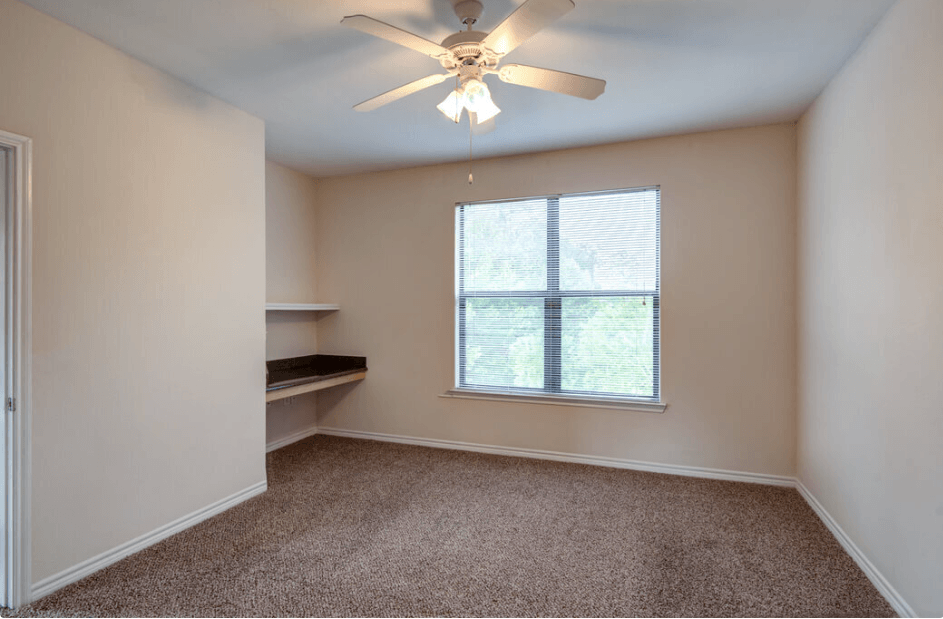 a bedroom with a ceiling fan and a window