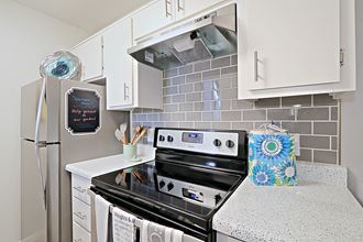a small kitchen with white cabinets and stainless steel appliances