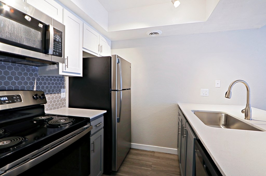 a kitchen with white countertops and black appliances