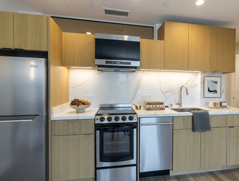 A modern kitchen with stainless steel appliances and wooden cabinets.