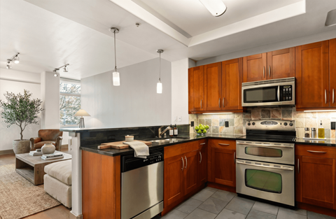 A modern kitchen with wooden cabinets and stainless steel appliances.