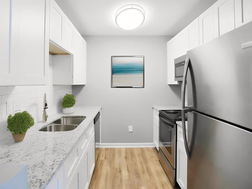 a modern kitchen with stainless steel appliances and white cabinets