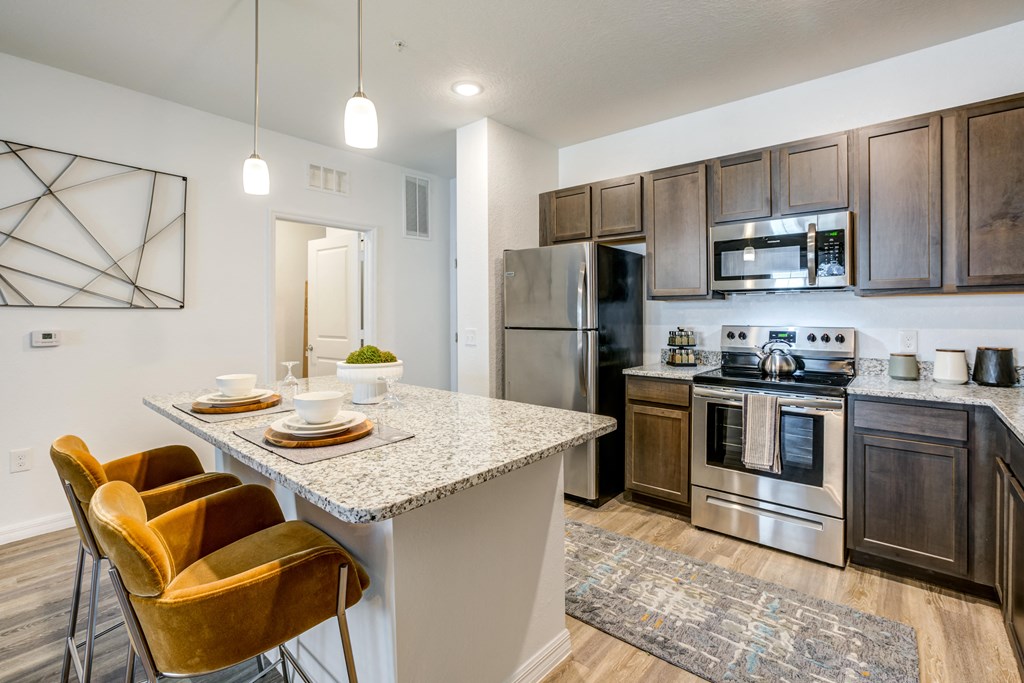 a kitchen with stainless steel appliances and a marble counter top