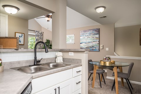 A kitchen with a table and chairs in the middle of the room.