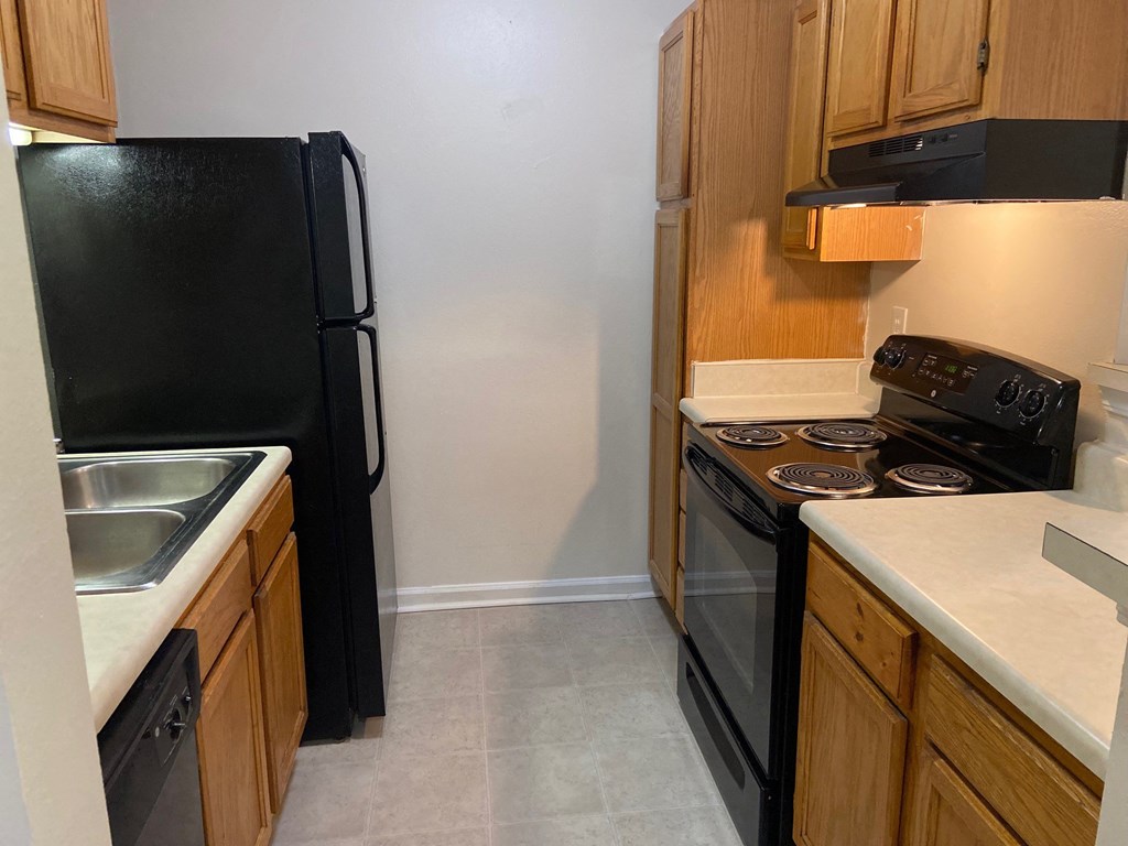 a kitchen with black appliances and wood cabinets
