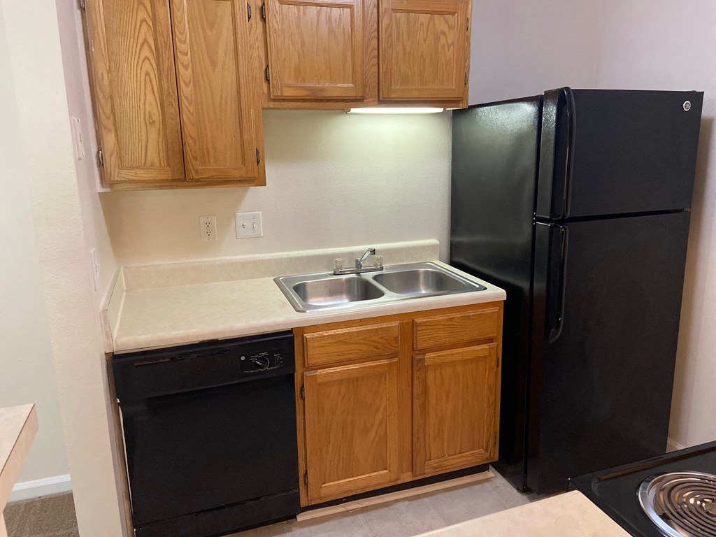 a kitchen with black appliances and wood cabinets