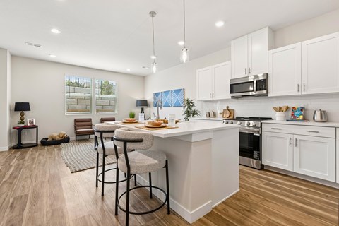 A modern kitchen with a dining area and a view of the backyard.