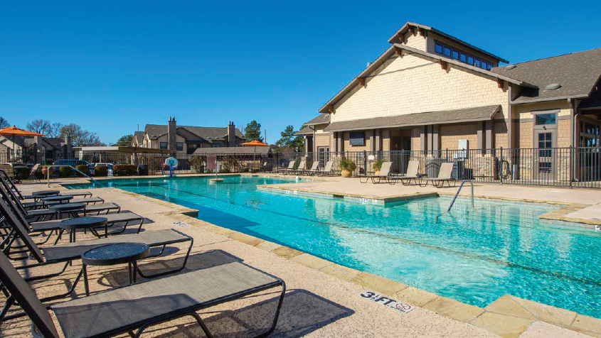 a swimming pool with lounge chairs next to a building