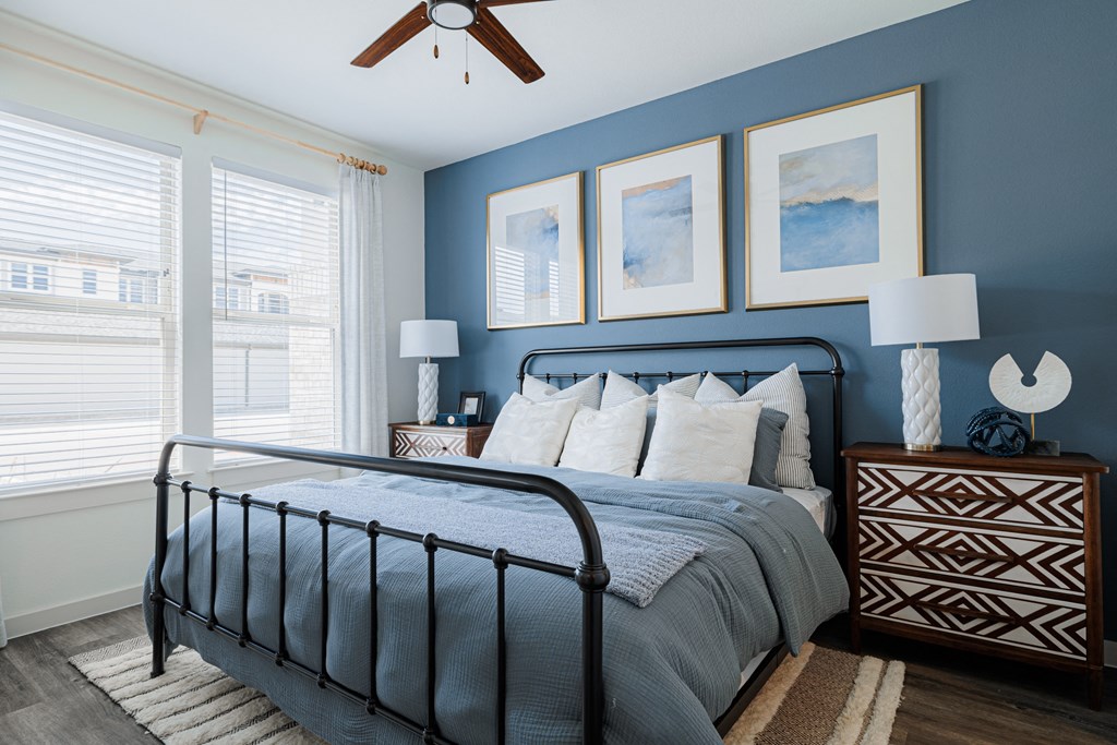 a bedroom with blue walls and a ceiling fan