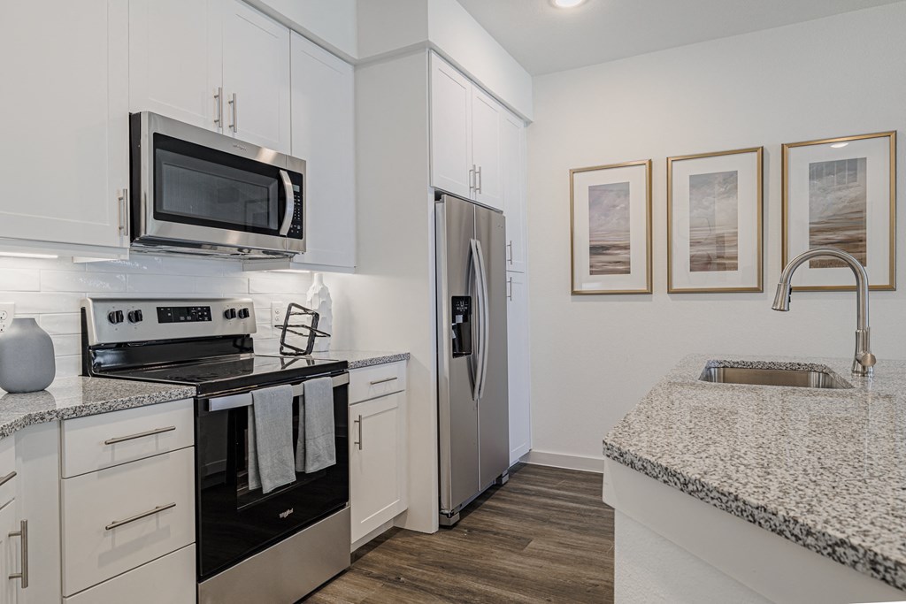 a kitchen with white cabinets and black appliances