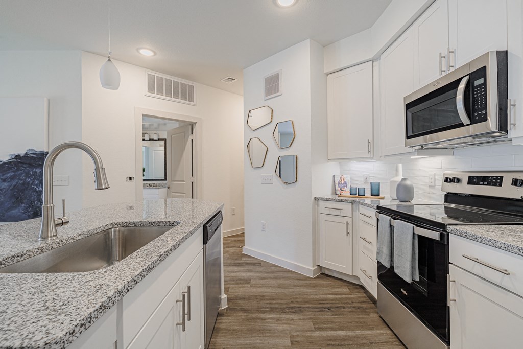 a kitchen with white cabinets and black appliances
