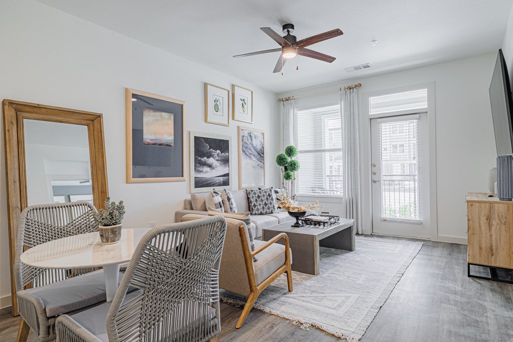 a living room with a ceiling fan and a large window