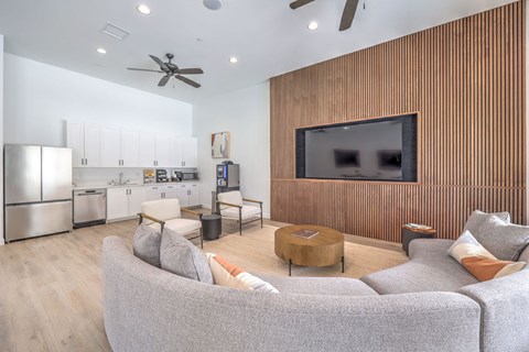 A modern living room with a grey couch and a wooden wall panel.