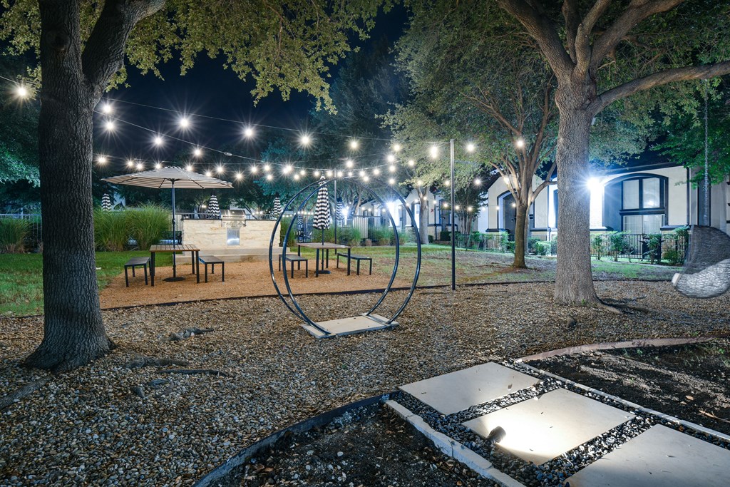 a night view of a park with trees and lights