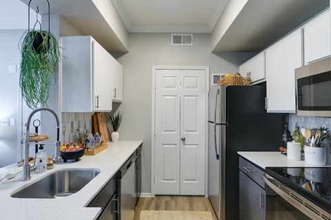a kitchen with white cabinets and a sink and a refrigerator
