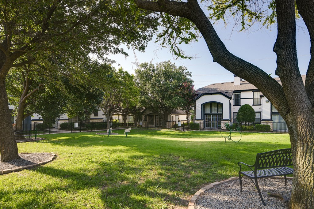 a park with trees and a bench in front of a building