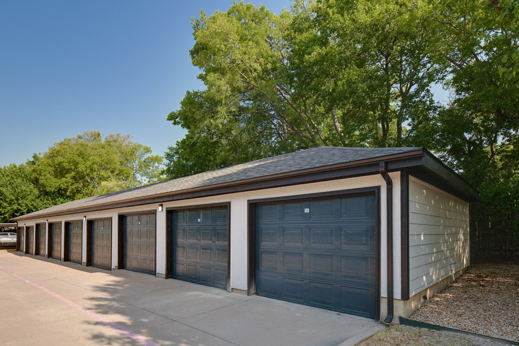 a row of garages in front of trees
