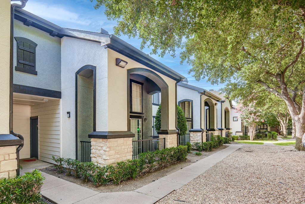 a row of houses with trees and a sidewalk