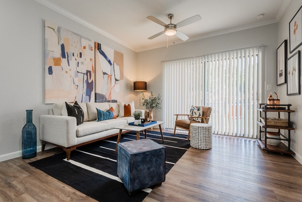 a living room with a white couch and a ceiling fan