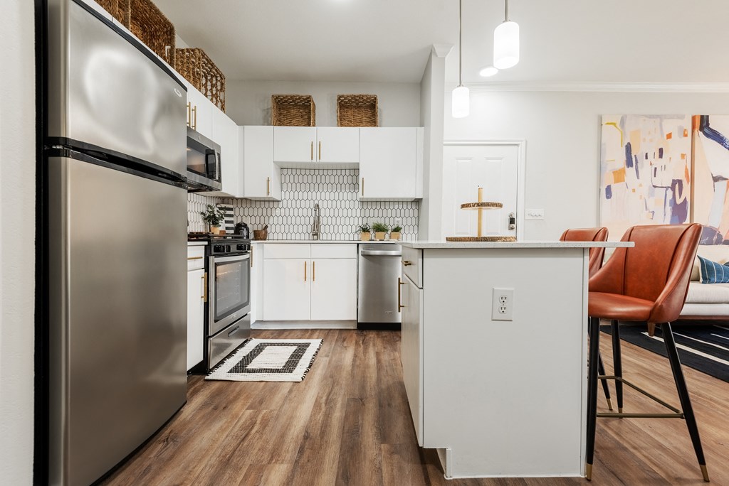 a white kitchen with stainless steel appliances and a counter top