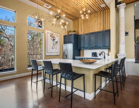 a kitchen with a large island with bar stools and blue cabinets