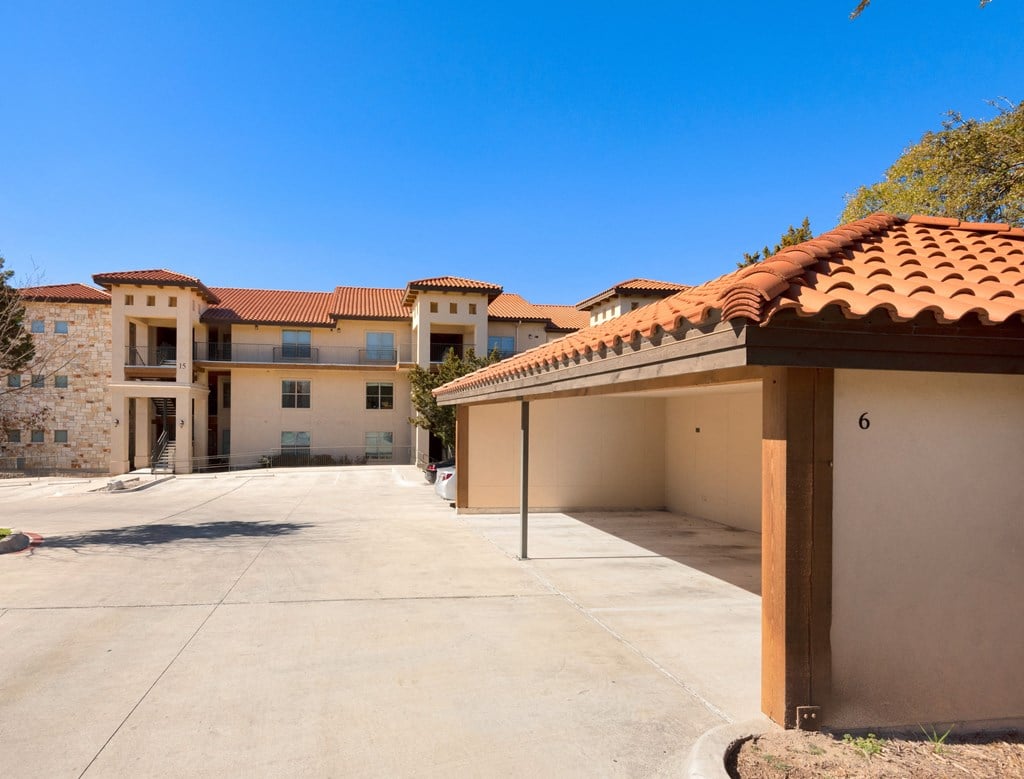 a covered parking lot in front of a building