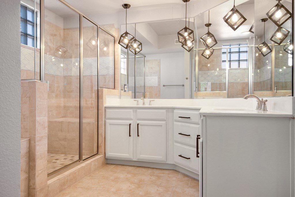 a bathroom with a large shower and two sinks