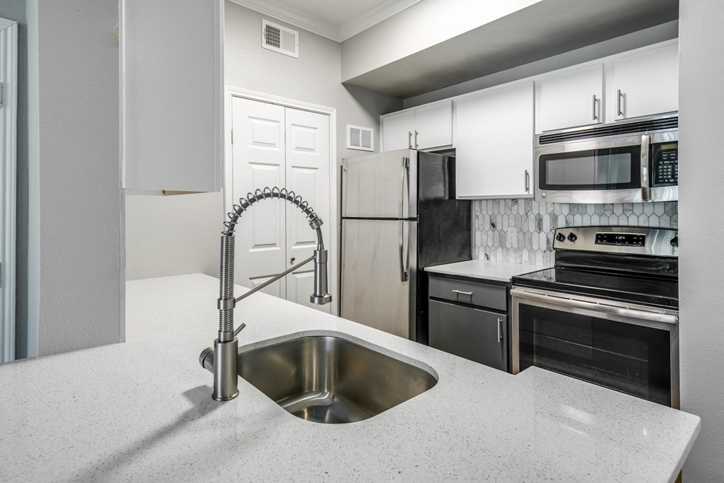 a kitchen with white cabinets and stainless steel appliances