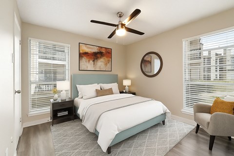A bedroom with a large bed and a ceiling fan.