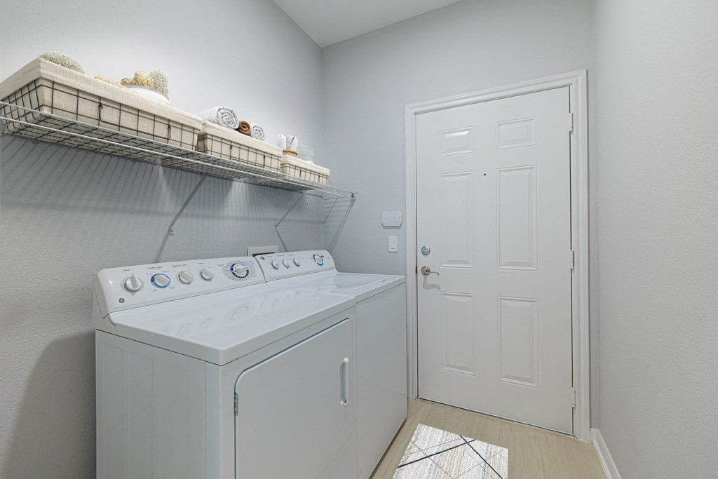 a white washer and dryer in a laundry room with a white door