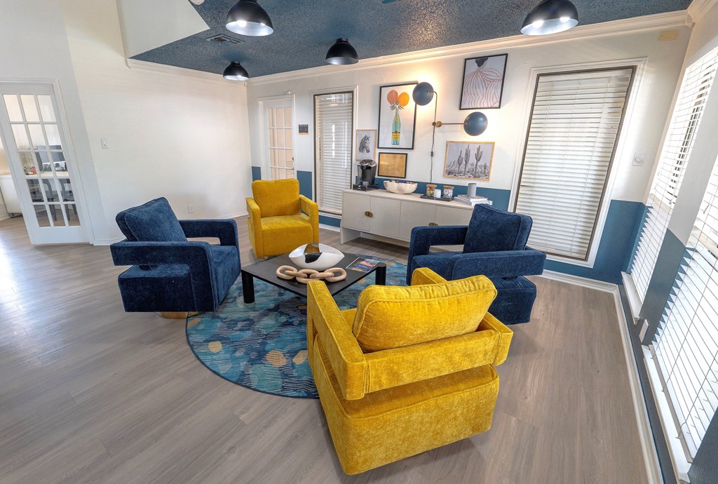 A living room with a yellow couch and blue chairs.