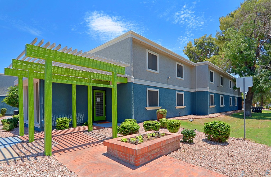 a house with a green pergola in front of it