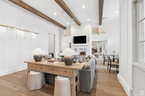A modern living room with a wooden table and grey couch.