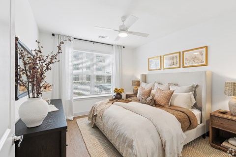 A bedroom with a large bed and a ceiling fan.